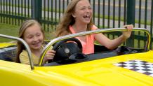 two girls driving a taxi on thunder alley at the great escape.