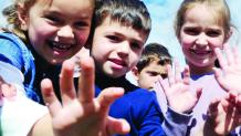 Kids smiling and waving at The Great Escape for Autism Awareness Day