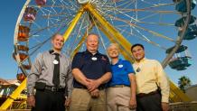 Six Flags employees standing in front of a ferris wheel