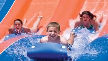 Young boy having fun on a water slide at Six Flags Great Escape