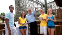 Teacher pointing to ride on platform of wooden roller coaster