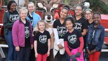 group of girls standing with a reindeer