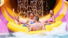 Family riding water slide at Hurricane Harbor at Six Flags Great Escape.