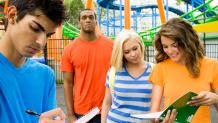 Teens doing schoolwork at a theme park