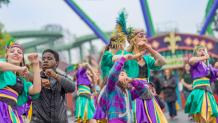 guests dancing with Party Gras performers in the park
