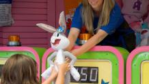 Games worker handing guest a prize