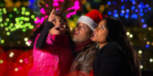 Family of three looking at lights in awe.