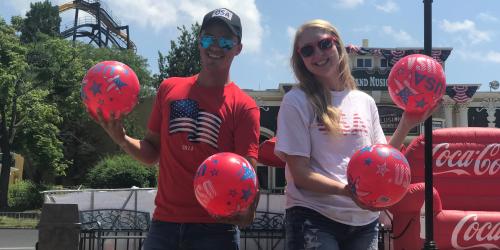 Two people wearing red white and blue and playing Coca Cola games in Hometown Square