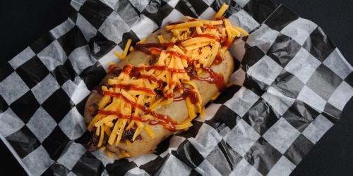 Pulled pork hot dog with cheese and sauce