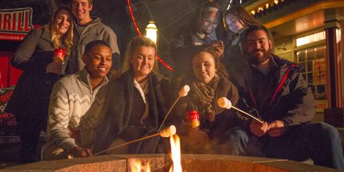 Group gathered around the fire with coasters in the background