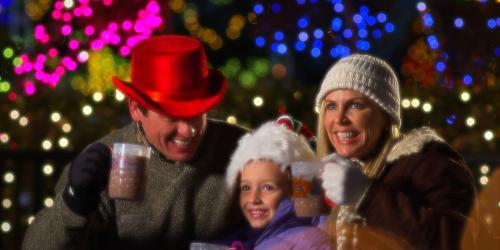 Family curled up looking at lights with hot chocolate