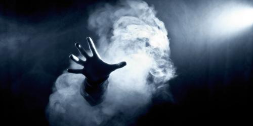 Hand through smoke in the dark