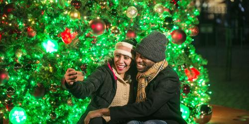 Guests taking a selfie in front of a christmas tree