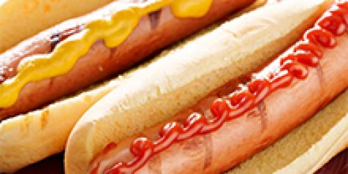 Two hot dogs on plate one with mustard, one with ketchup