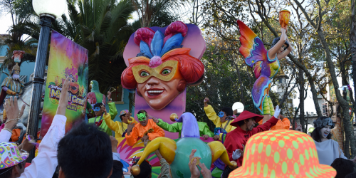 Mardi Gras Parade Float with Head as the Mast and large crowd of people watching
