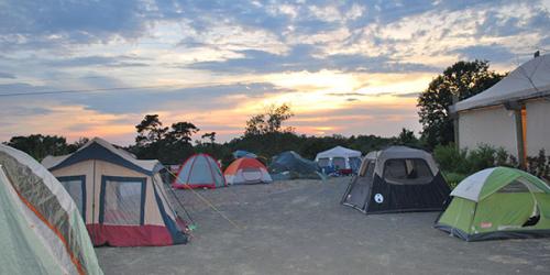 Tents in safari while sun sets in background