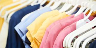 T-shirt display rack with several shirts of various colors