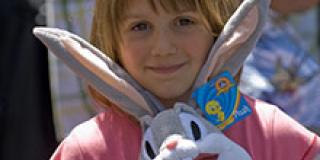 Small child smiling and holding a Bugs Bunny stuffed animal Small child smiling and holding a Bugs Bunny stuffed animal