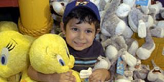 Child holding <em>Looney Tunes</em> stuffed toys Child holding <em>Looney Tunes</em> stuffed toys
