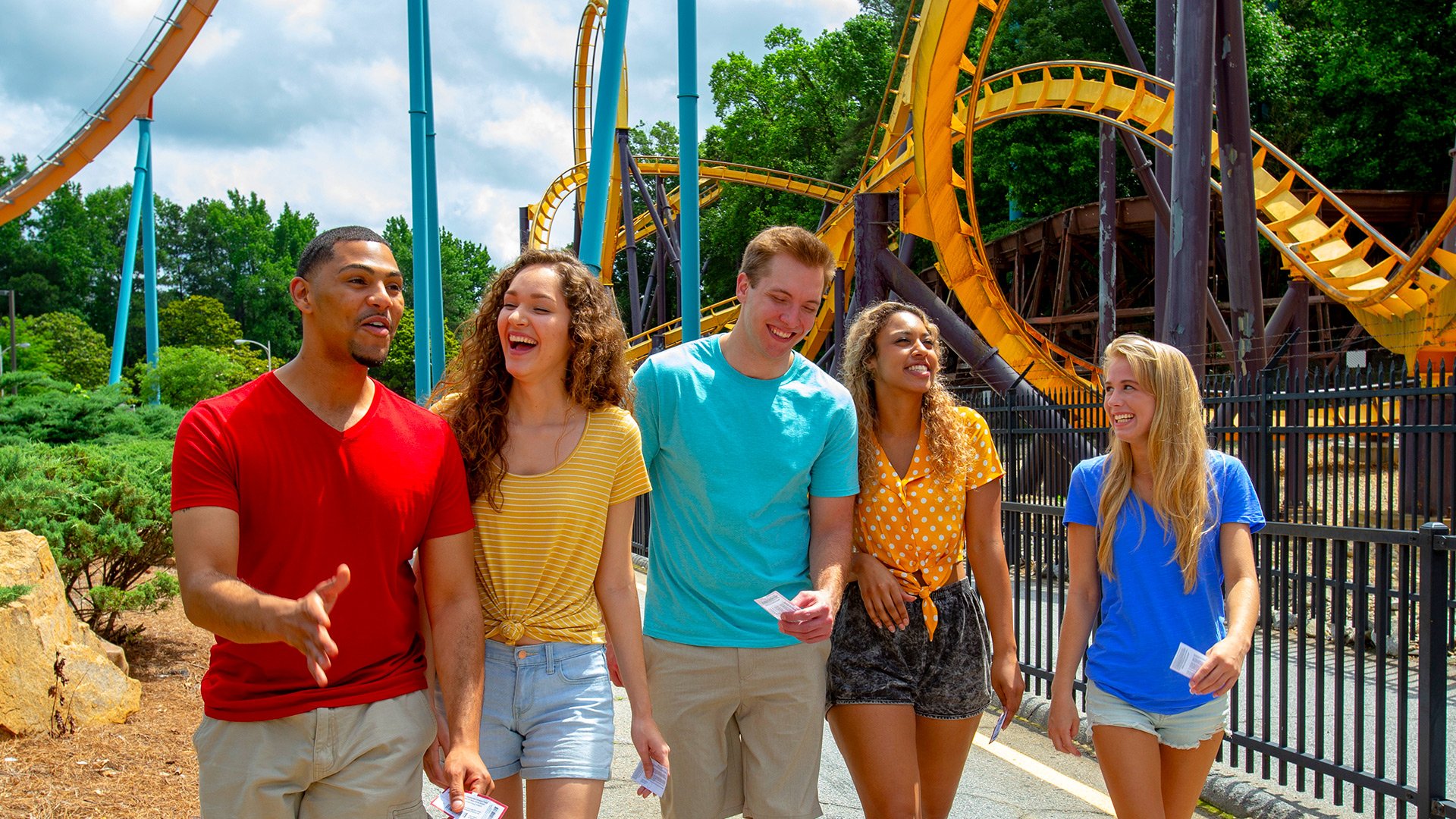 A group of people laughing and talking at Six Flags theme park
